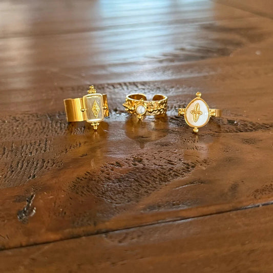 Three gold rings with mother-of-pearl stone accents