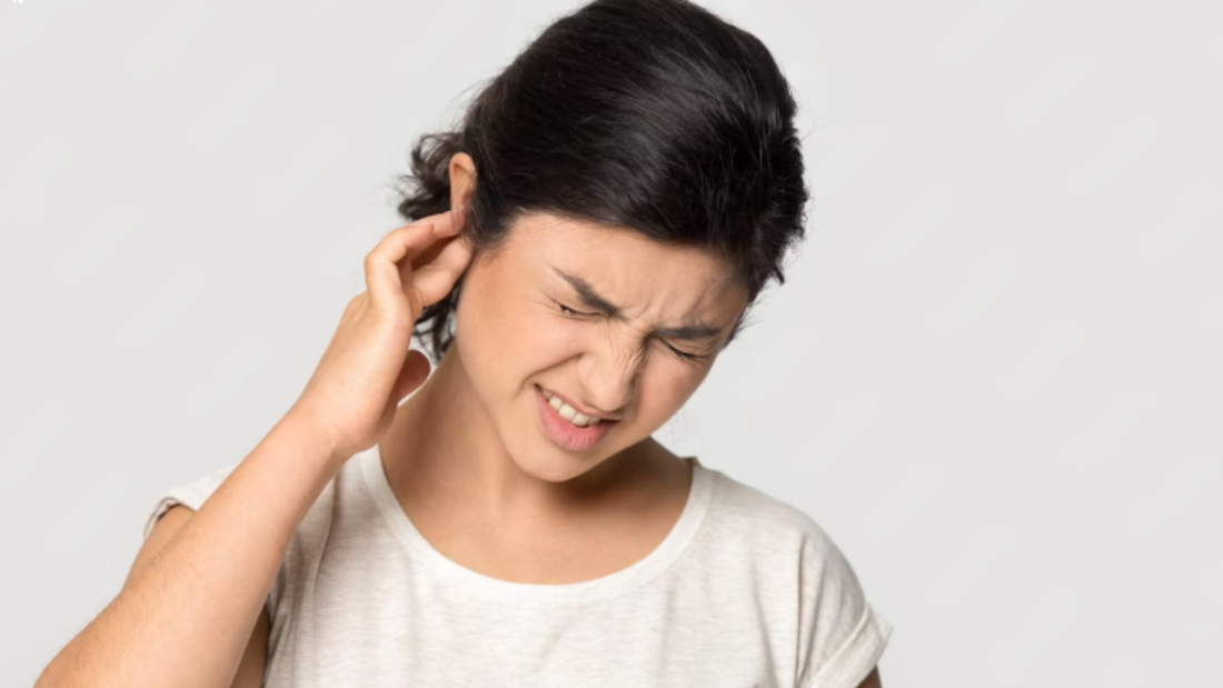 Woman experiencing pain in one of her ears.